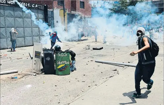  ?? RONALDO SCHEMIDT / AFP ?? Los opositores devuelven los botes de humo que lanza la policía venezolana en el centro de Caracas