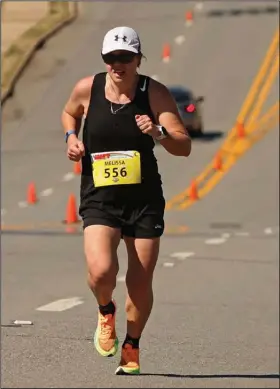  ?? (Arkansas Democrat-Gazette/Colin Murphey) ?? Melissa Hambuchen (left) of Conway runs up Cantrell Road in Little Rock on Sunday during the final stages of the 21st Little Rock Marathon. Hambuchen finished second with a time of 3 hours, 13 minutes, 19 seconds.