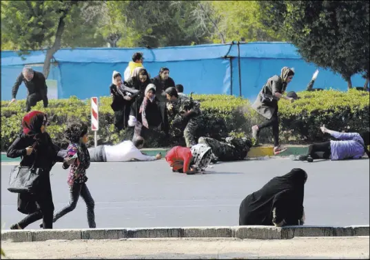  ?? The Associated Press ?? Civilians try to take shelter during a shooting Saturday at a military parade in Ahvaz, Iran.