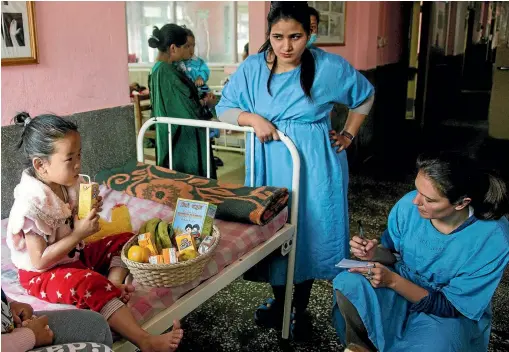  ?? PHOTOS: WARWICK SMITH/STUFF ?? BVS volunteer co-ordinator Laetitia Vanderstic­helen, right, visits the burns ward of Kanti Children’s Hospital, where families are given nutrition baskets and support.