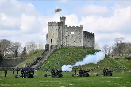  ?? Matthew Horwood/Getty Images ?? Above: Reservists from 104 Regiment Royal Artillery fire guns during a Death Gun Salute to mark the death of Prince Philip, Duke of Edinburgh, on Saturday at Cardiff Castle in Cardiff, Wales. Gun salutes are customaril­y fired, both on land and at sea, as a sign of respect or welcome. Below: Britain’s Prince Philip waits for the bridal procession Oct. 12, 2018, after the wedding of Princess Eugenie of York and Jack Brooksbank in St. George’s Chapel, Windsor Castle, near London.