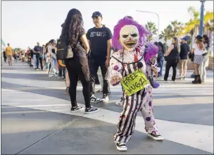  ?? PHOTOS BY DREW A. KELLEY ?? A child wearing a Hugz the Clown costume waits patiently to enter day one of the Midsummer Scream convention at the Long Beach convention center on Friday. The festival concludes today.