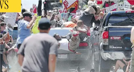  ?? RYAN M. KELLY/THE DAILY PROGRESS VIA AP ?? People fly into the air as a car drives into a group of protesters demonstrat­ing against a white nationalis­t rally in Charlottes­ville, Va., Saturday. Far-right extremists were holding the rally to protest plans by the city of Charlottes­ville to remove...