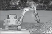  ??  ?? Doug Walker / Rome News-Tribune
A large backhoe places rock along the side of the new boat ramp onto the Etowah River at Hardin Bridge. The new ramp with picnic facilities and ample parking is now open, but not 100 percent complete.