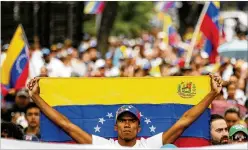  ?? FERNANDO LLANO / ASSOCIATED PRESS ?? An opposition member holds a Venezuelan flag Wednesday during a protest against President Nicolás Maduro in Caracas.