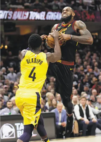  ?? Tony Dejak / Associated Press ?? Cleveland’s LeBron James is hounded by Indiana’s Victor Oladipo during this drive to the basket in Game 1 of their series in Cleveland. Oladipo had 32 points; James had a triple-double.
