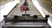  ?? RICHARD DREW — THE ASSOCIATED PRESS FILE ?? The American flag flies above the Wall Street entrance to the New York Stock Exchange.