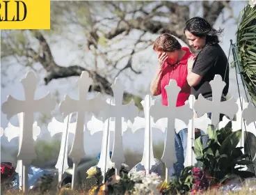  ?? SCOTT OLSON / GETTY IMAGES ?? Maria Durand, left, and her daughter Lupita Alcoces visit a memorial Tuesday where 26 crosses stand to honour the 26 victims killed in a mass shooting at the First Baptist Church of Sutherland Springs, Texas. Durand, who helps to teach Bible study at...
