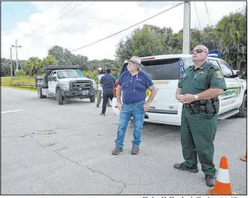  ?? Phelan M. Ebenhack The Associated Press ?? A Sarasota County Sheriff ’s Office deputy and a Sarasota County worker stand at the entrance to the Carlton Reserve on Tuesday during a search for Brian Laundrie.