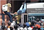  ??  ?? Desperate students scramble over the gates to secure registrati­on at Unisa’s Sunnyside campus.