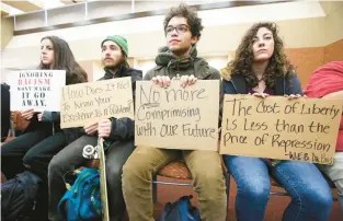  ?? AMBER ARNOLD/WISCONSIN STATE JOURNAL ?? University of Wisconsin-Madison students hold up signs protesting racism on campus during a meeting for the UW System Board of Regents.