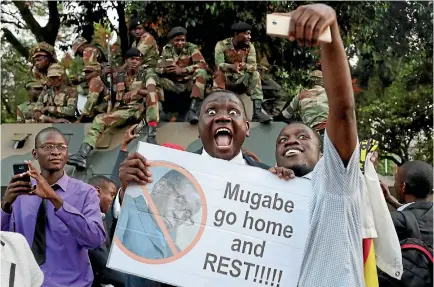  ?? PHOTO: REUTERS ?? Zimbabwean­s celebrate in Harare after President Robert Mugabe resigned yesterday.