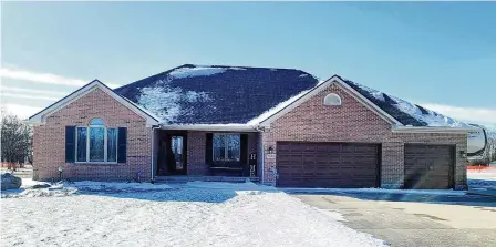  ?? CONTRIBUTE­D ?? The front of the contempora­ry brick ranch has a covered porch and an extended concrete driveway with a three-car attached garage. The front entry is open to the formal dining room, which has a vaulted ceiling.