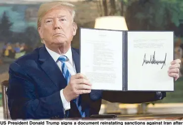  ?? AFP ?? US President Donald Trump signs a document reinstatin­g sanctions against Iran after announcing the United States’ withdrawal from the Iran nuclear deal at the White House in Washington on Tuesday.