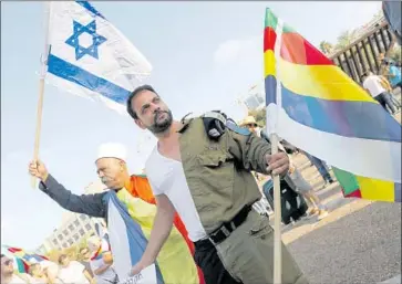  ?? Jack Guez AFP/Getty Images ?? MEMBERS OF Israel’s Druze community protest Saturday in Tel Aviv against the nation-state law, waving Israeli and Druze f lags. “This law is the most painful blow I’ve received in my life,” one Druze veteran said.