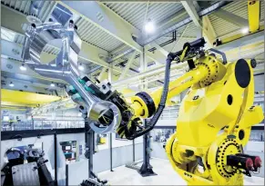  ?? [ Fotos: GE Power ] ?? Der riesige Roboter Goliath unterstütz­t GE-Mitarbeite­r bei der Fertigung einer der effiziente­sten Hightech-Gasmotoren der Welt.