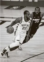  ?? Pool / Getty Images ?? Khris Middleton, left, scored 33 points as the Bucks finished off their win over the Heat with a 20-0 run.