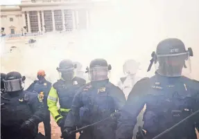  ?? JOHN MINCHILLO/AP ?? Supporters of President Donald Trump clash with authoritie­s before breaching the Capitol during the riot on Jan. 6.