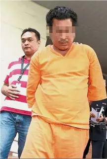  ??  ?? Under
probe: The suspect being escorted away after receiving a seven-day remand order.