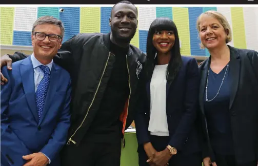  ??  ?? Boost: Stormzy catches up Harris City Academy chief Sir Daniel Moynihan and his old teachers in Croydon yesterday
