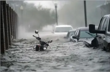  ?? GERALD HERBERT — THE ASSOCIATED PRESS FILE ?? Flood waters move on the street, in Pensacola, Fla., on Sept. 16. Hurricane Sally made landfall near Gulf Shores, Alabama, as a Category 2 storm, pushing a surge of ocean water onto the coast and dumping torrential rain. This year has seen record Atlantic hurricanes and western wildfires, devastatin­g floods in Asia and Africa and a hot, melting Arctic. It’s not just been a disastrous year, but a year of disasters.