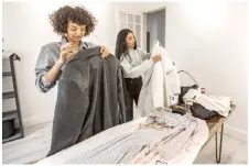  ?? ?? Abdallah (left) and Zeina Ehab try on clothes during a photo session.