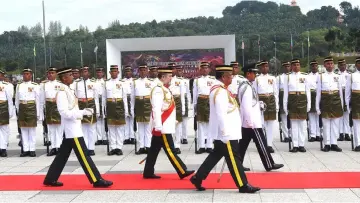  ??  ?? Sultan Muhammad V inspects the guard-of-honour. — Bernama photos