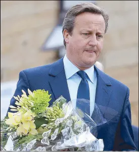 ??  ?? Prime Minister David Cameron prepares to lay floral tributes for British member of parliament Jo Cox in Birstall, northern England.