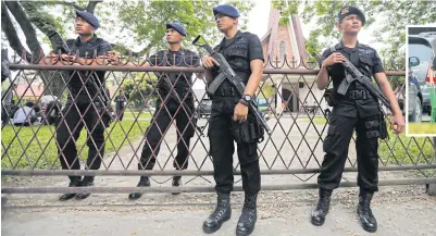  ?? EPA ?? LEFT Indonesian mobile brigade policemen stand guard at the church yesterday.