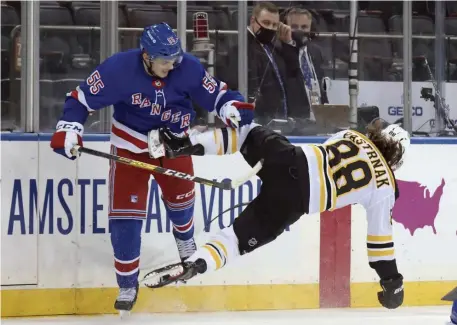  ?? AP ?? A TUMULTUOUS NIGHT: New York Rangers’ Ryan Lindgren, left, tosses Bruins forward David Pastrnak for a tumble during their game Friday in New York.