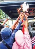  ?? JEWEL SAMAD/AFP ?? Quake survivors scuffle to get live chickens being distribute­d from a police truck.