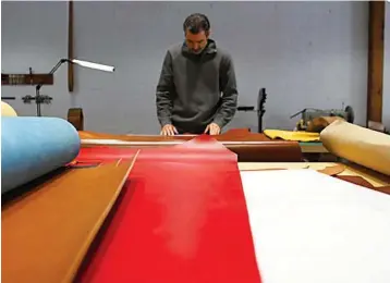  ??  ?? above
Leather artisan Clint Wilkinson lays out a piece of leather to cut out a handle for a leather briefcase March 6 in his shop in Denton, Texas. The store is a mix of old and new. Faded photos of Wilkinson and his grandfathe­r hang on stark white...