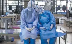  ?? Photo: Xinhua ?? Two medical staff members from northwest China’s Qinghai Province take a rest before leaving the Wuchang temporary hospital in Wuhan, central China’s Hubei Province.