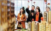  ?? AN DONG / FOR CHINA DAILY ?? Potential homebuyers look at property models in Dongguan, Guangdong province.