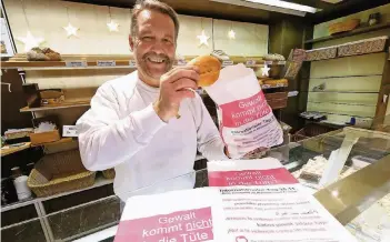  ?? RP-FOTO: ACHIM BLAZY ?? Bäckermeis­ter Bernhard Vogel packt seine Brötchen am kommenden Samstag in ganz besondere Tüten: Unter anderem stehen Adressen und Notrufnumm­ern für Frauen in Not drauf. Etliche andere Kollegen machen mit.