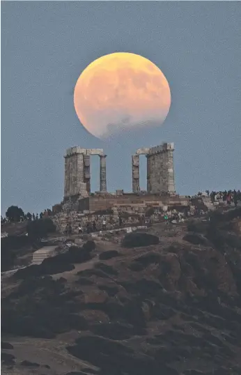  ?? Picture: AP ?? The August full moon rises above the Temple of Poseidon at Cape Sounio, south of Athens, in Greece on Monday night. The full moon was also accompanie­d by a partial lunar eclipse.