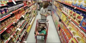  ?? AP PHOTO/TONY GUTIERREZ, FILE ?? Alicia Ortiz shops through the cereal aisle as her daughter Aaliyah Garcia catches a short nap in the shopping cart at a Family Dollar store in Waco, Texas. Don’t be intimidate­d by the idea of a weekly big supermarke­t shop. Buying a lot in one fell swoop helps keep your kitchen organized ad well-stocked all week.