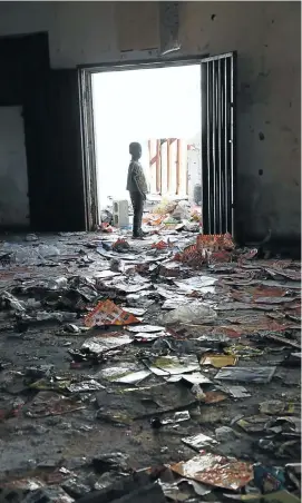  ??  ?? TAKING STOCK: A child surveys the gutted interior of the Amazambane supermarke­t in KwaMashu after a mob of looters had broken into it and carried off the stock