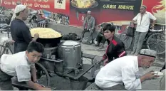  ?? THE ASSOCIATED PRESS FILES ?? Uighurs rest near a food stall in Kashgar in China’s western Xinjiang province. Human Rights Watch said Tuesday that China appears to be laying the groundwork for the mass collection of DNA samples from residents in the restive region.