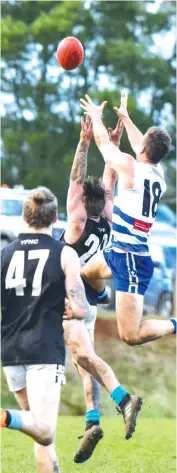  ??  ?? Neerim-Neerim South’s Tyssen Morrow flies over Yarragon’s Ben Virgona in a marking contest.