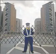  ?? (AP/Hiro Komae) ?? A guard stands in front of a fence to close off a constructi­on site for the athletes’ village to be used during the Tokyo 2020 Olympic and Paralympic Games in Tokyo.