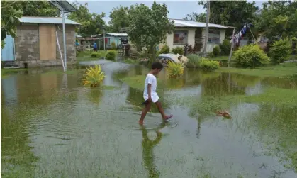  ?? Photograph: Chameleons­eye/Getty Images ?? An Indigenous Fijian girl walks over flooded land after Cyclone Winston in 2016. The UN committee says the planetary crisis is is ‘an urgent and systemic threat to children’s rights globally’.