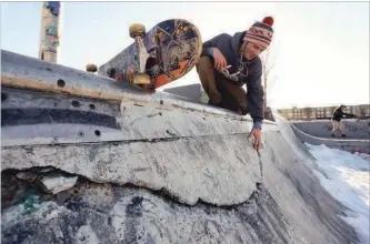  ?? CLIFFORD SKARSTEDT EXAMINER ?? Chris Morton looks at cracks in the concrete at West 49 Skate Park. City council is voting Monday on a plan to spend $150,000 on repairs at the park in 2020.