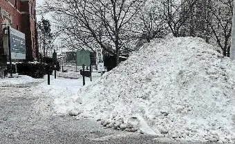  ?? DEVIN SISAK ?? A snowbank blocks an accessible parking space in the Mill Street lot behind Art of Home. Devin Sisak of BarrierFre­e Cambridge has taken it upon himself to clear snow from such spaces when the city fails to do so in a timely manner, but some spaces are impossible to clear by hand.