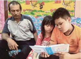  ?? (Foto Rosman Shamsudin/bh) ?? Mohd Aiman Syukur (kanan) dan Mahnas Hibatullah Syazana melihat gambar ibu mereka sambil diperhatik­an Mahmud Rahman di Behrang, semalam.