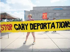  ??  ?? Organizer Loren Ezra Whitman adjusts a banner during a rally in protest of ICE raids, deportatio­ns, and detention camps on July 20, 2019, in Hammond.