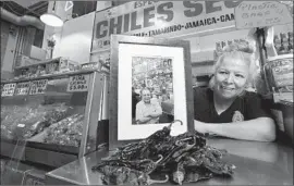  ?? Mel Melcon Los Angeles Times ?? ROCIO LOPEZ holds a photo of her father, Celestino Lopez, who ran the Chiles Secos stand at Grand Central Market before he turned it over to family members.