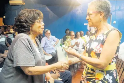  ?? PHOTOS BY MARCIA ROWE ?? Marjorie Whylie (left) is presented with an award by Fae Ellington.