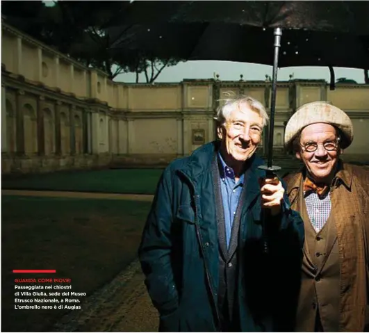  ??  ?? GUARDA COME PIOVE! Passeggiat­a nei chiostri di Villa Giulia, sede del Museo Etrusco Nazionale, a Roma. L’ombrello nero è di Augias