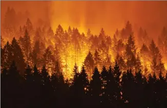  ?? The Associated Press ?? A wildfire continues to burn on the Oregon side of the Columbia River Gorge near Cascade Locks, Ore.